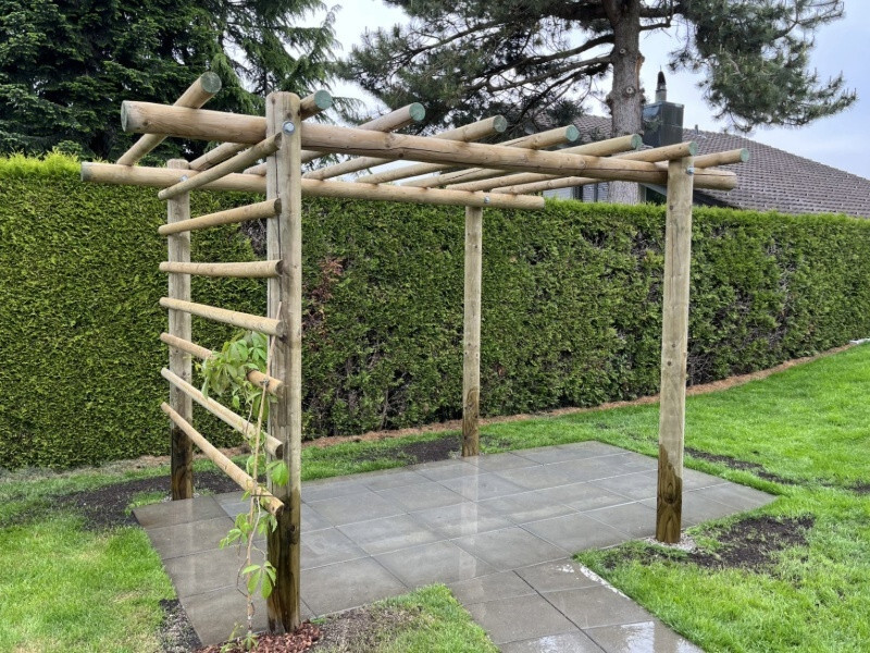 Rundholzpergola mit Rankhilfe als Sitzplatz